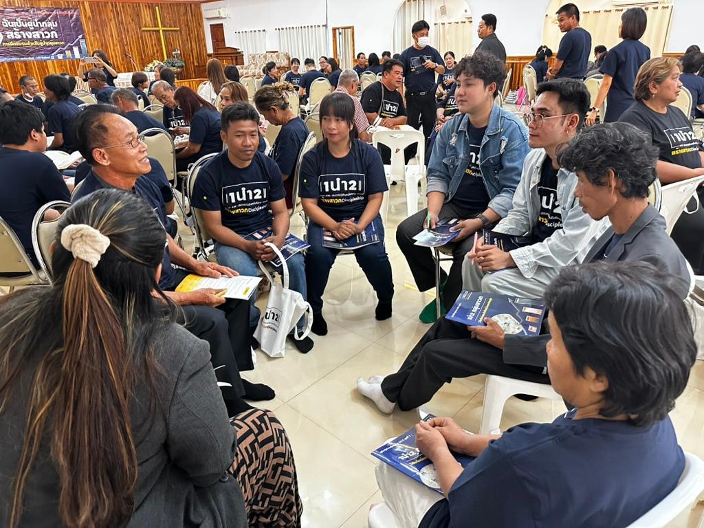 Believers in 1นำ2 shirts practicing in small circles during training